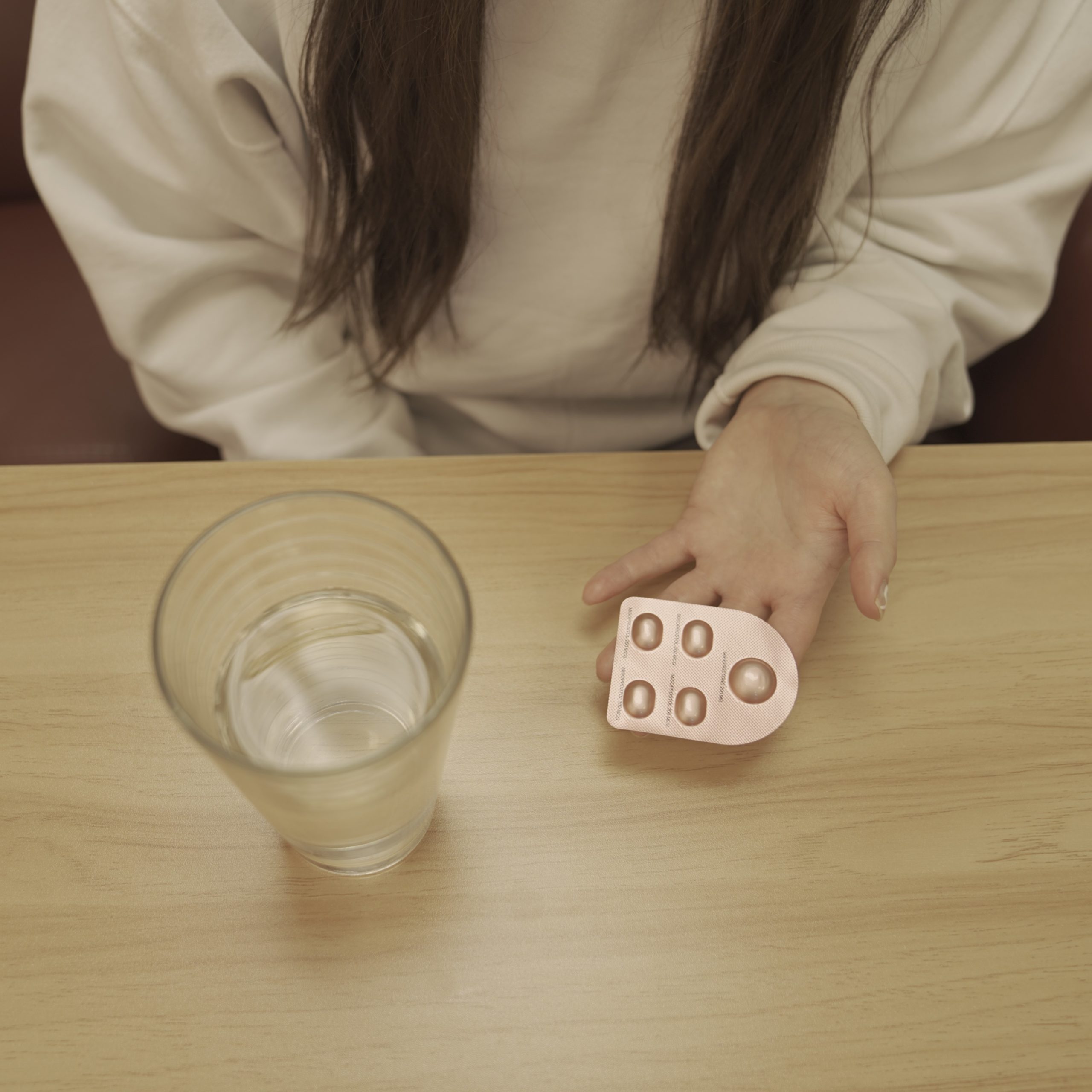 woman holding mail-in abortion pill and water