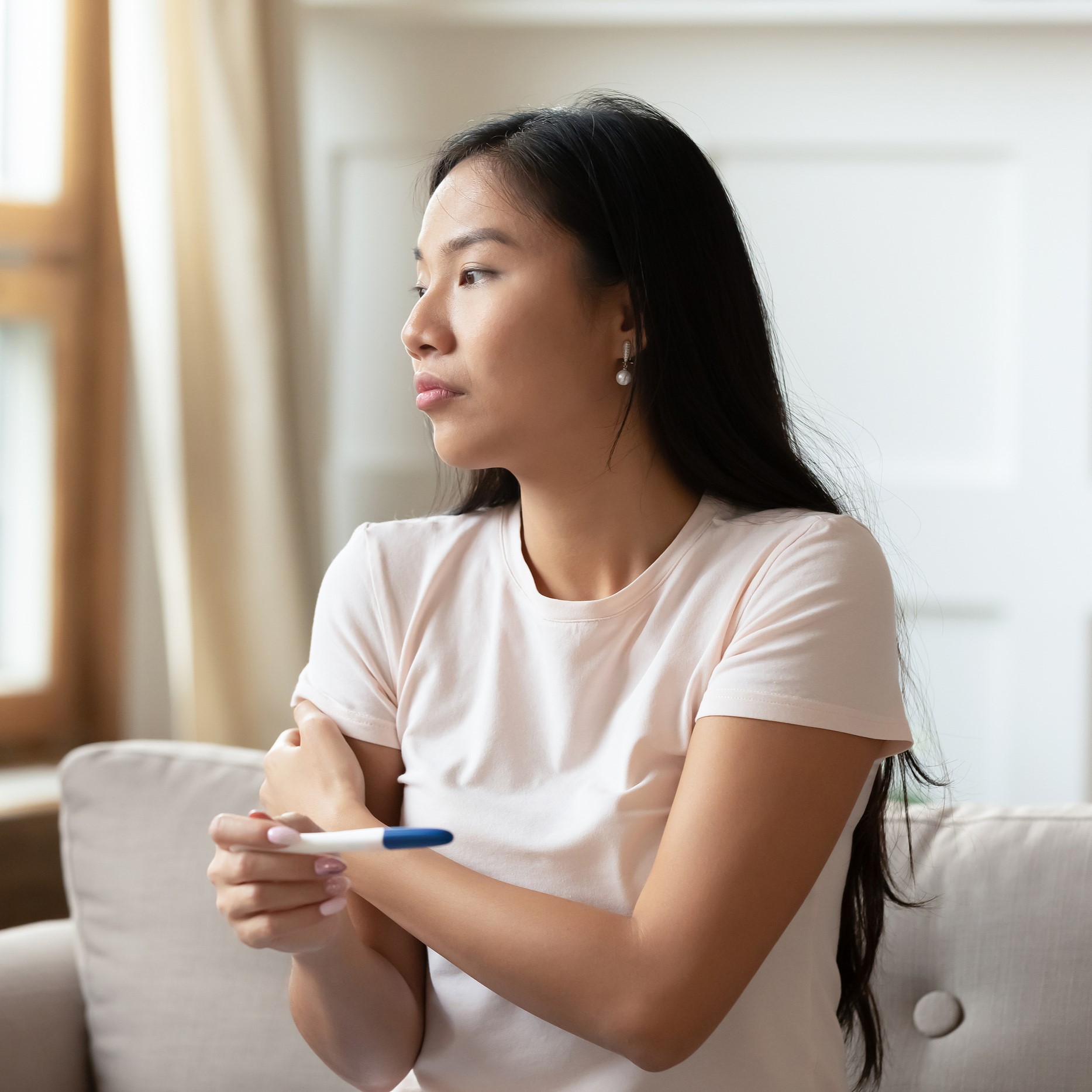 Asian woman holding pregnancy test